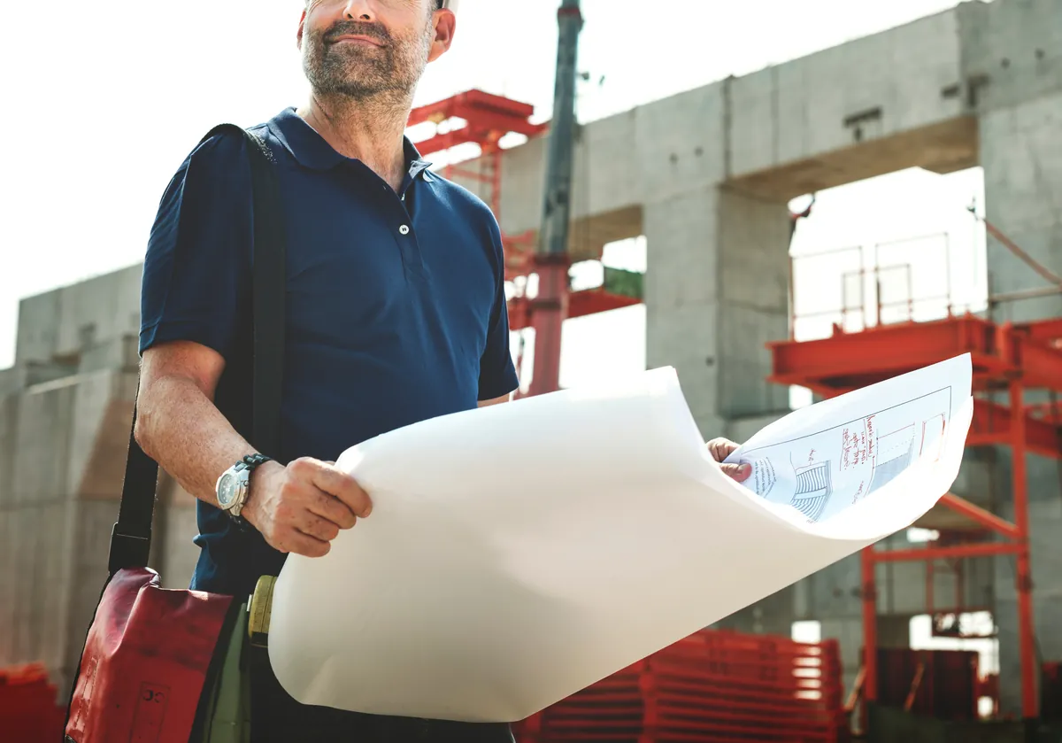 Engenheiro analisando projeto em canteiro de obras